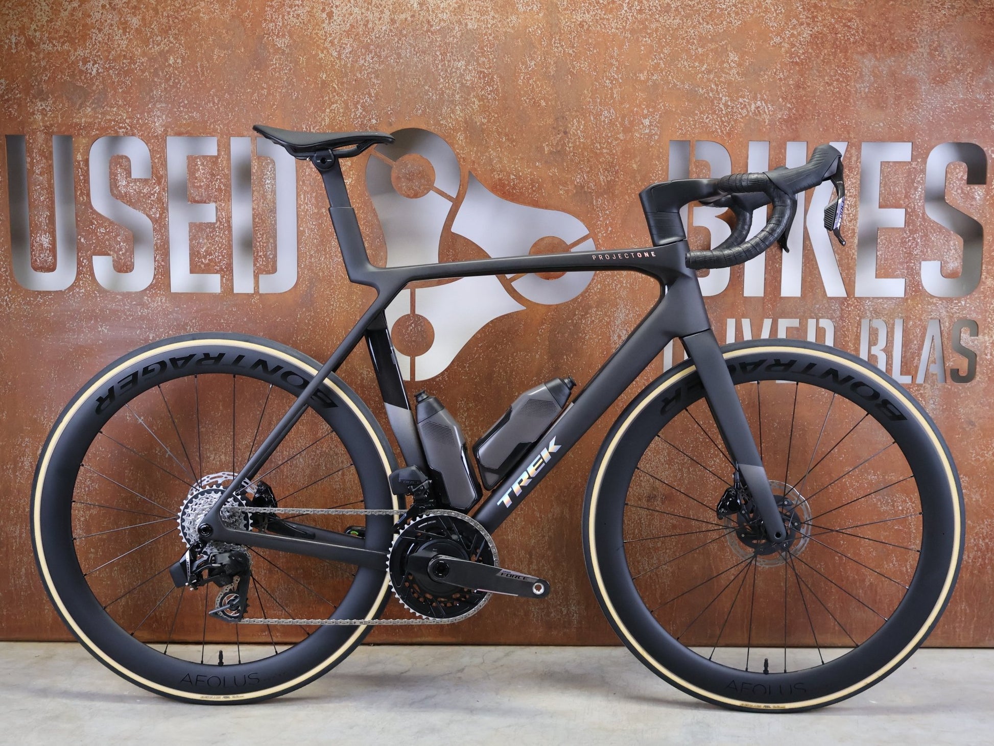 Rennrad von Trek, TREK MADONE SLR 7 AXS MY 2026 / MATTE CARBON SMOKE / L vor USEDBIKES - OB.DE Hintergrund