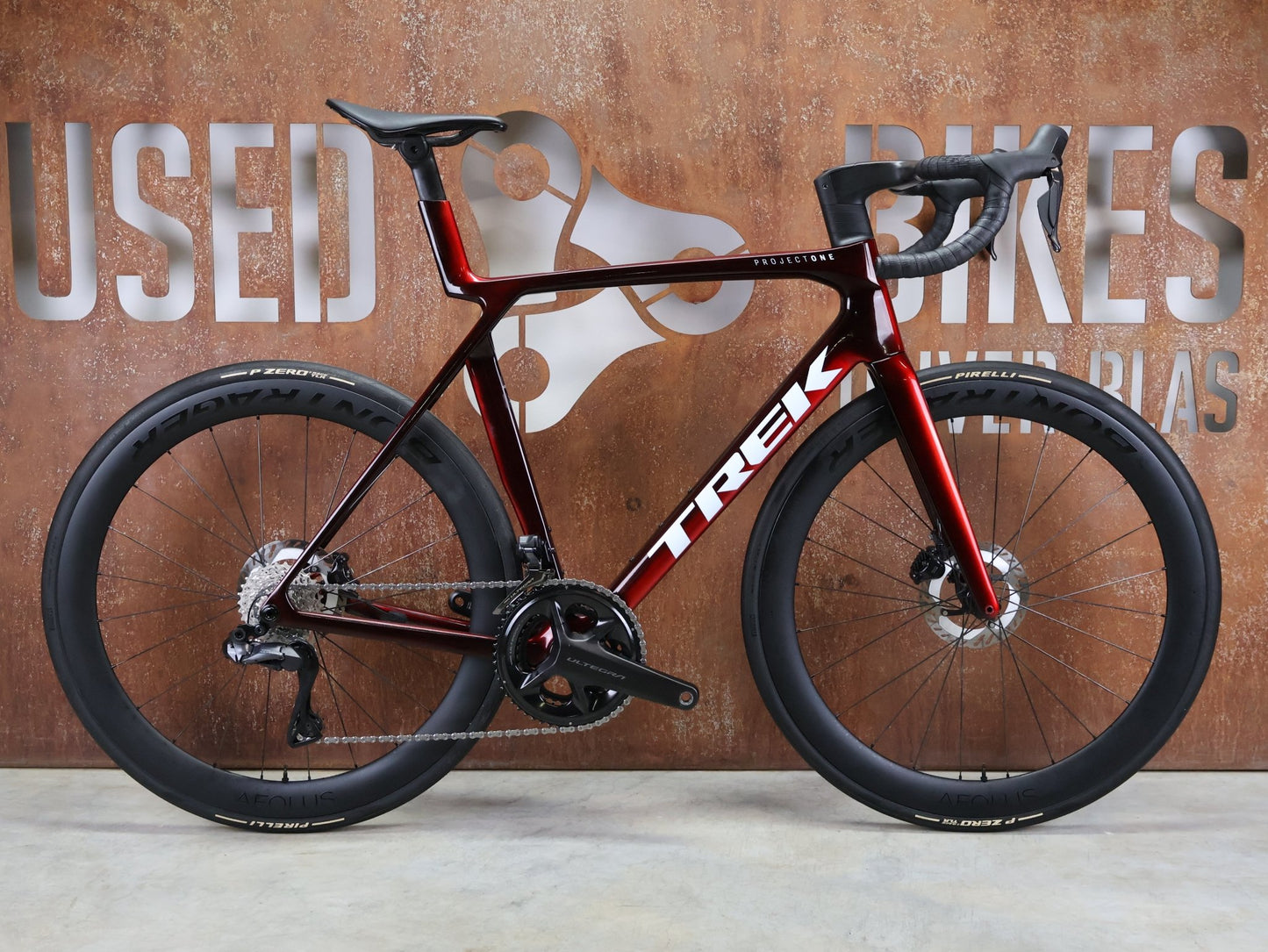 Rennrad von Trek, TREK MADONE SLR 7 GEN 8 / CARBON RED SMOKE / L vor USEDBIKES - OB.DE Hintergrund