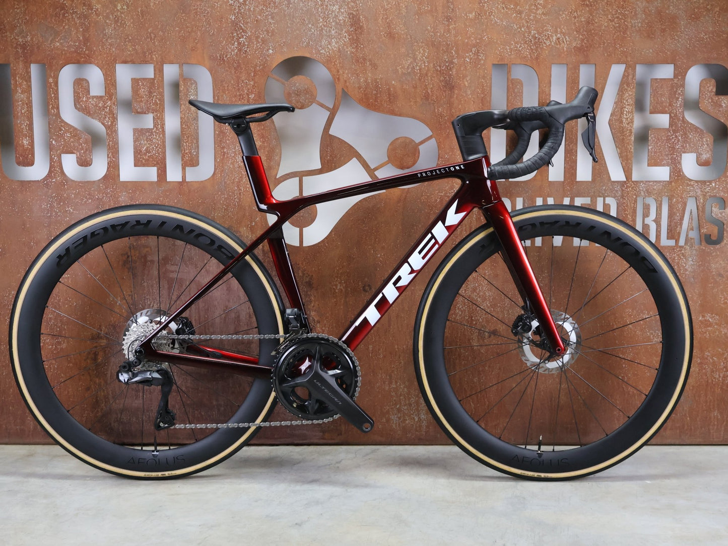 Rennrad von Trek, TREK MADONE SLR 7 GEN 8 / CARBON RED SMOKE / S vor USEDBIKES - OB.DE Hintergrund