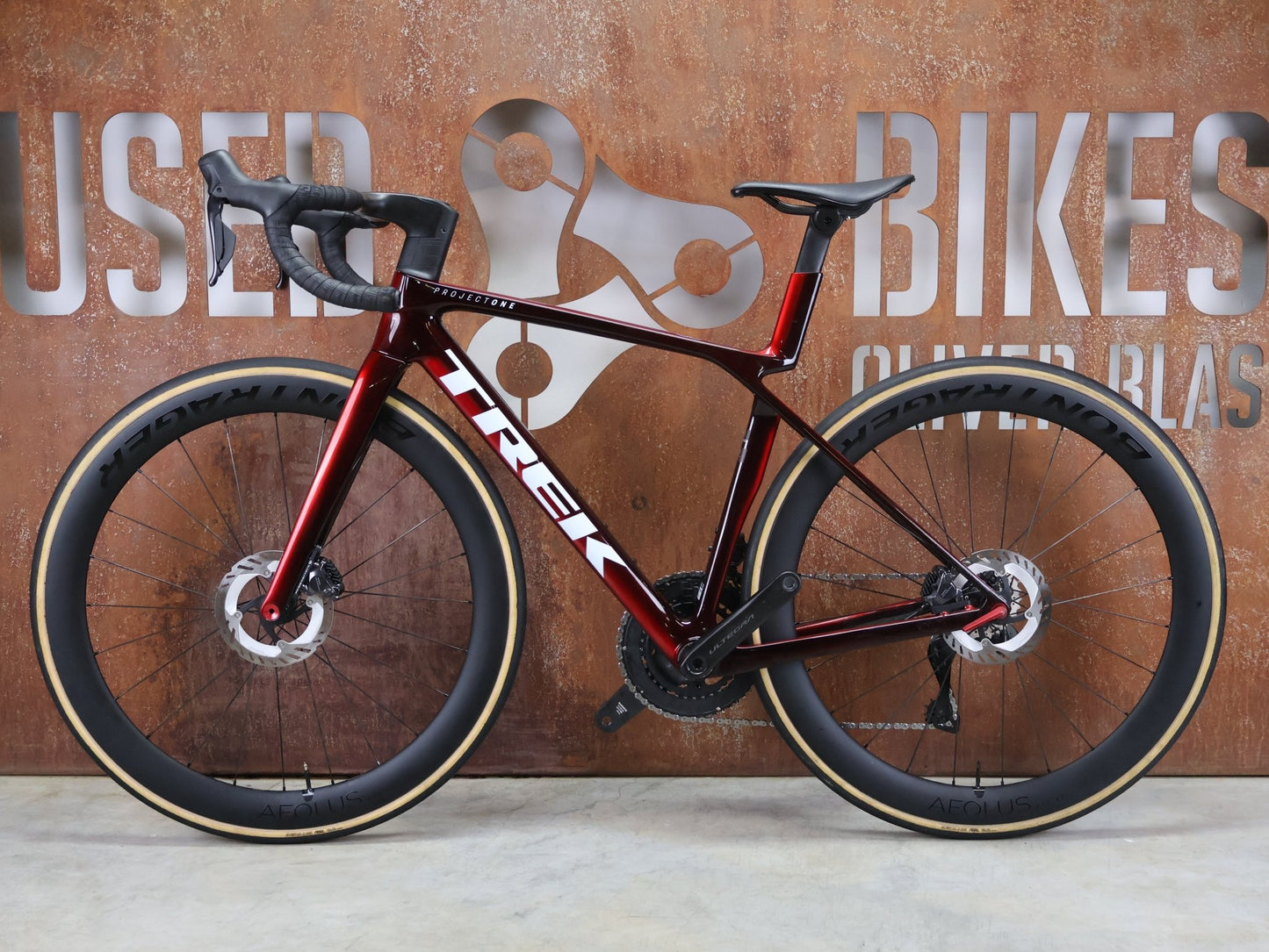 Rennrad von Trek, TREK MADONE SLR 7 GEN 8 / CARBON RED SMOKE / S vor USEDBIKES - OB.DE Hintergrund