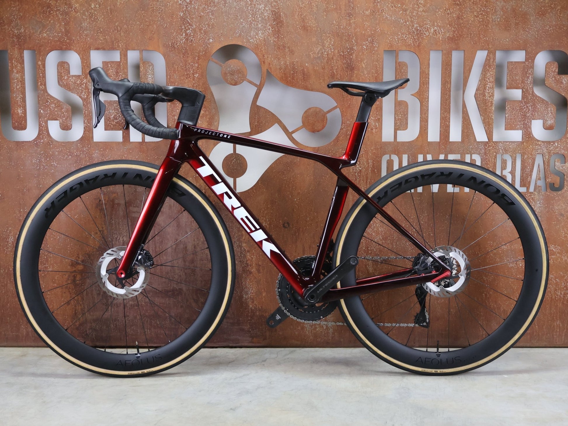 Rennrad von Trek, TREK MADONE SLR 7 GEN 8 / CARBON RED SMOKE / S vor USEDBIKES - OB.DE Hintergrund