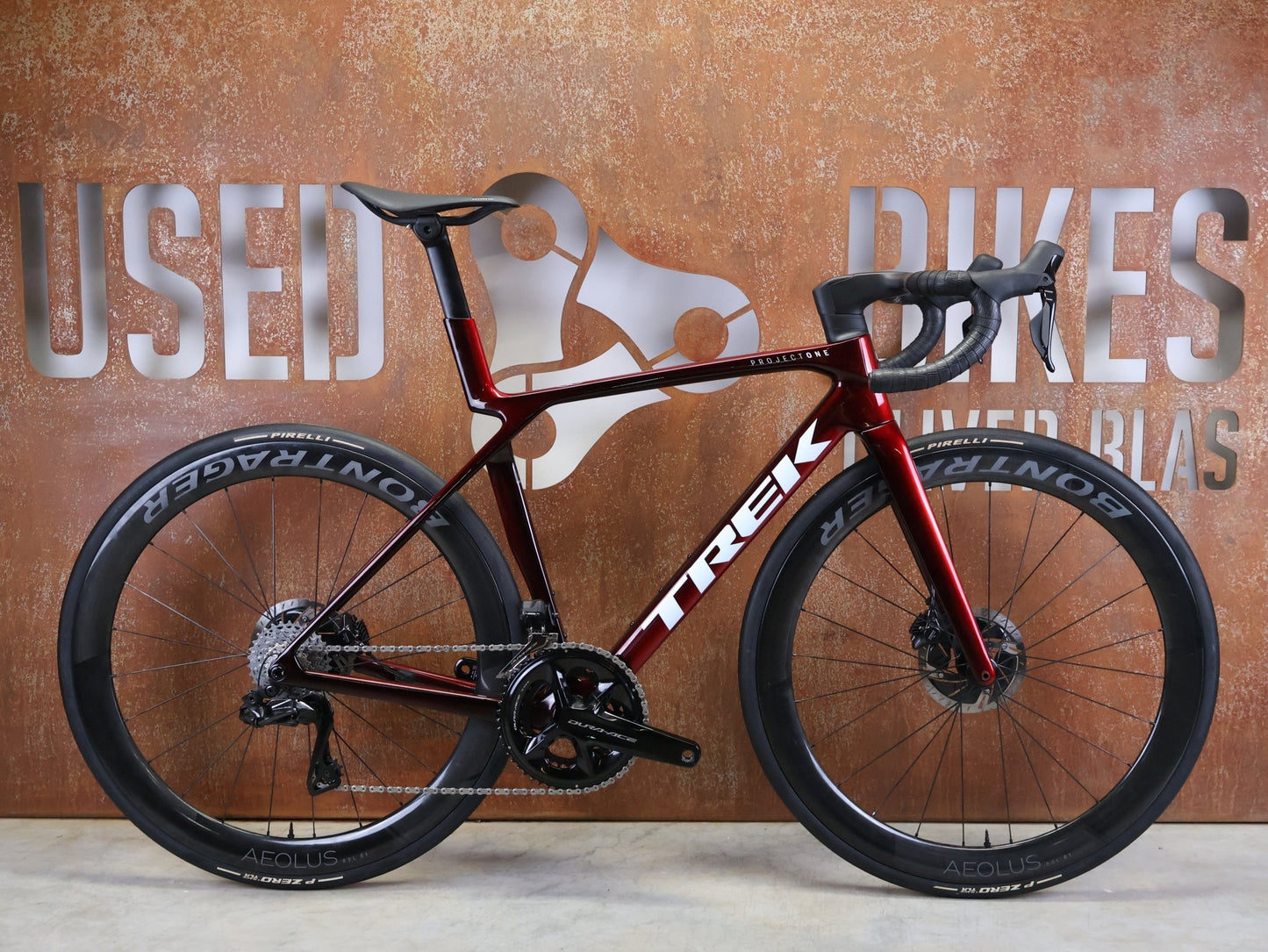 Rennrad von Trek, TREK – MADONE SLR 9 GEN 8 / DURA - ACE DI2 / CARBON RED SMOKE / M vor USEDBIKES - OB.DE Hintergrund
