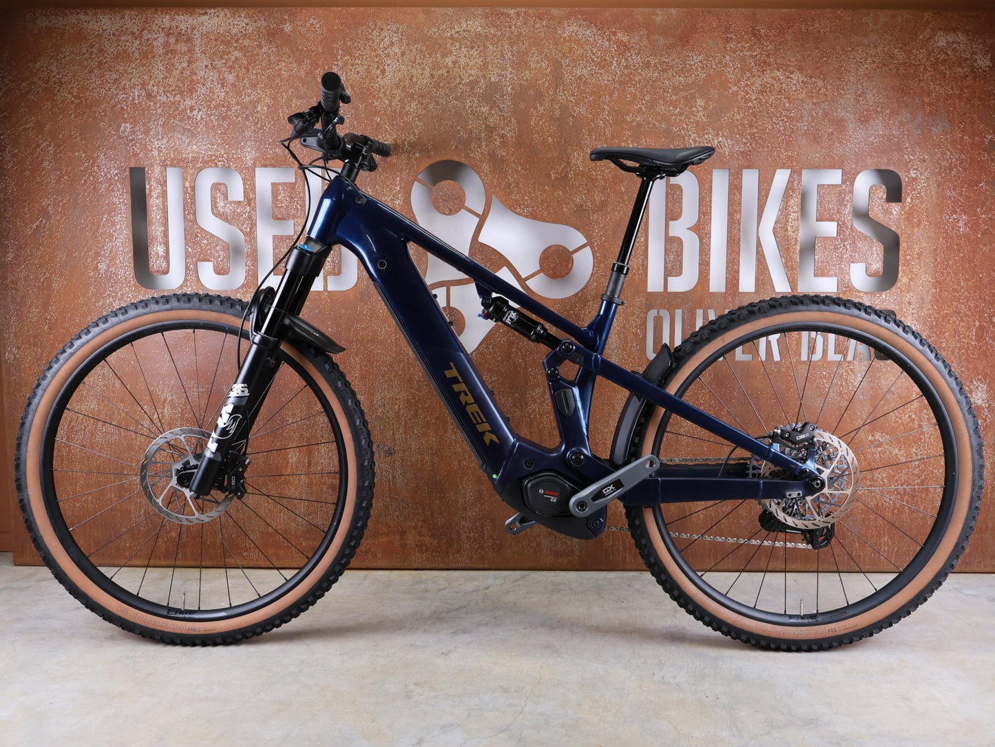 E - Mountainbike von Trek, TREK POWERFLY+ FS 8 GEN 4 / MATTE/GLOSS MULSANNE BLUE / L vor USEDBIKES - OB.DE Hintergrund