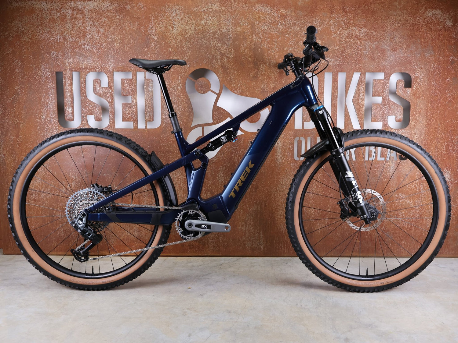 E - Mountainbike von Trek, TREK POWERFLY+ FS 8 GEN 4 / MATTE/GLOSS MULSANNE BLUE / L vor USEDBIKES - OB.DE Hintergrund