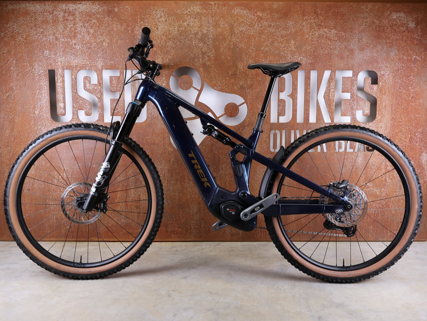 E - Mountainbike von Trek, TREK POWERFLY+ FS 8 GEN 4 / MATTE/GLOSS MULSANNE BLUE / M vor USEDBIKES - OB.DE Hintergrund