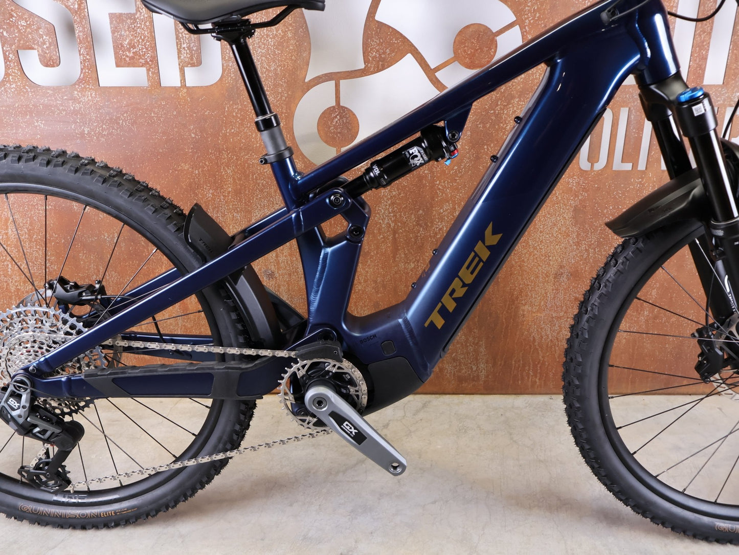 E - Mountainbike von Trek, TREK POWERFLY+ FS 8 GEN 4 / MATTE/GLOSS MULSANNE BLUE / S vor USEDBIKES - OB.DE Hintergrund