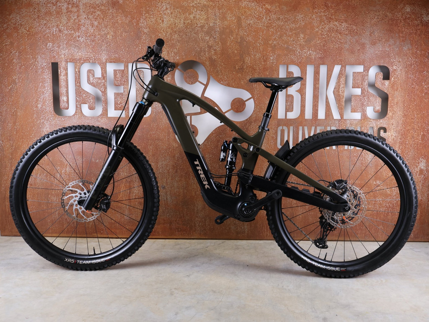 E - Mountainbike von Trek, TREK SLASH+ 9.7 SLX/XT / OLIVE DRAB / S vor USEDBIKES - OB.DE Hintergrund