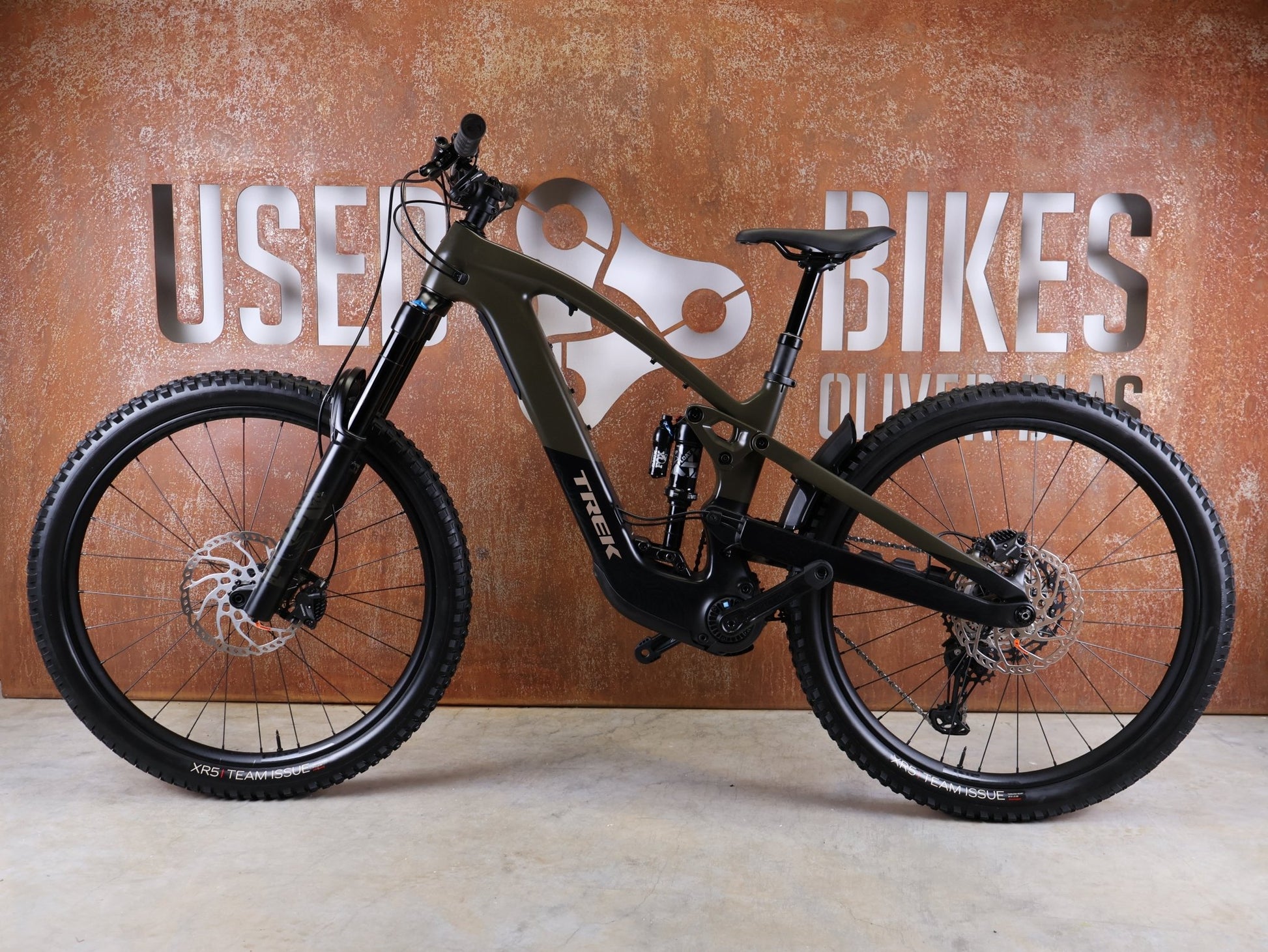 E - Mountainbike von Trek, TREK SLASH+ 9.7 SLX/XT / OLIVE DRAB / S vor USEDBIKES - OB.DE Hintergrund