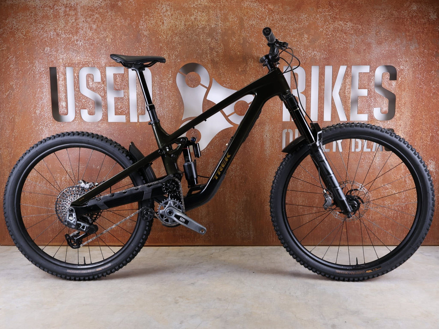 Mountainbike von Trek, TREK SLASH 9.8 GX AXS T - TYPE GEN 6 / BLACK OLIVE / M/L vor USEDBIKES - OB.DE Hintergrund