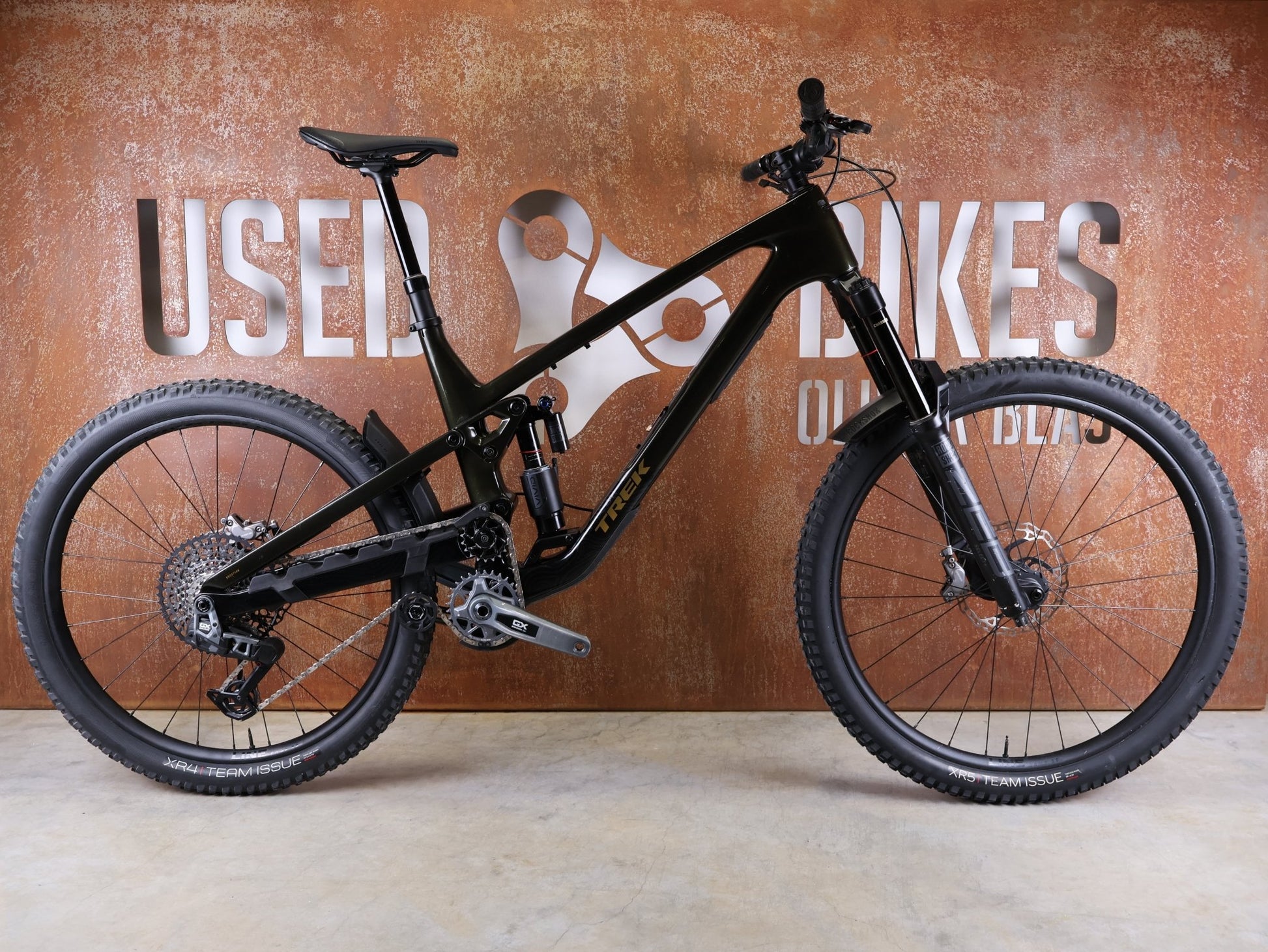 Mountainbike von Trek, TREK SLASH 9.8 GX AXS T - TYPE GEN 6 / BLACK OLIVE / XL vor USEDBIKES - OB.DE Hintergrund