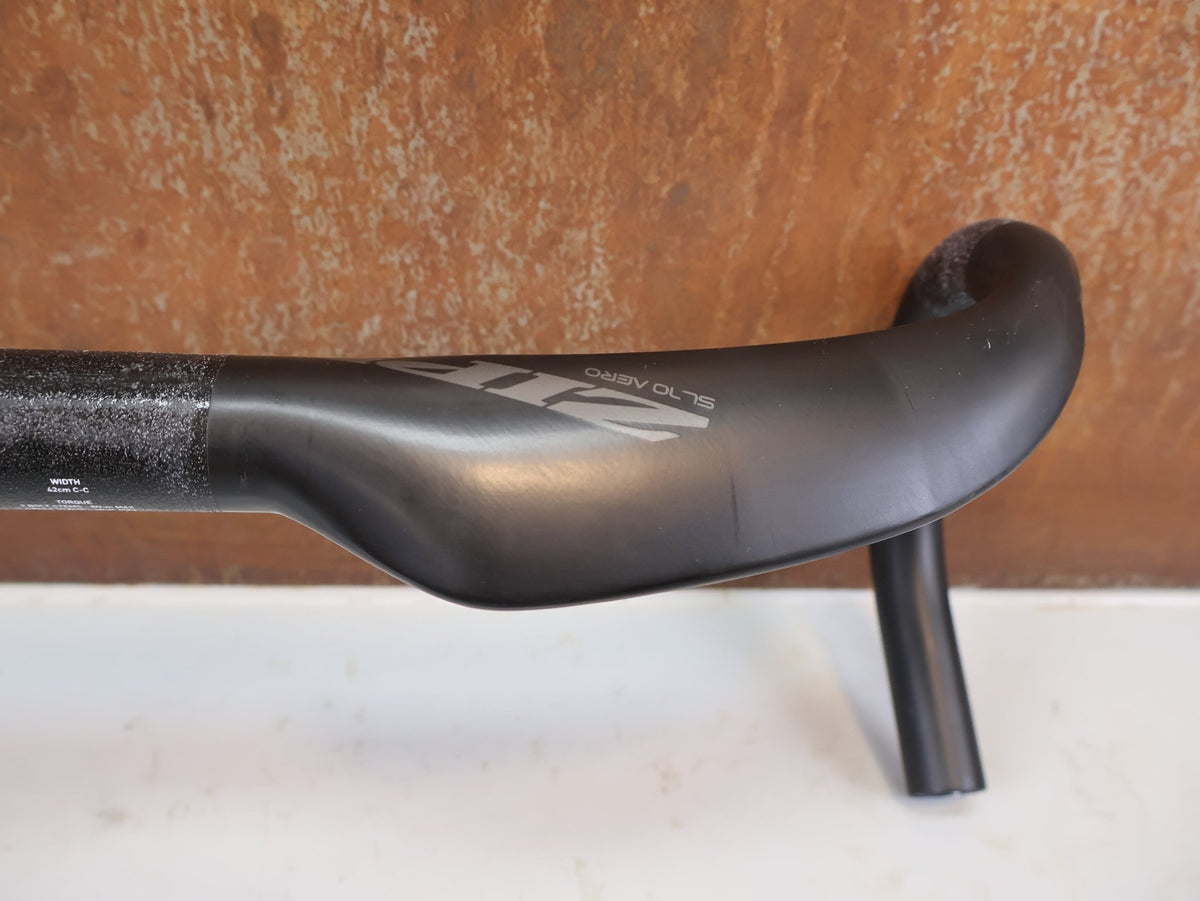 Lenker von Zipp, Zipp SL-70 Aero Carbon Lenker 42cm Matte Rapid Route / Bastlerware vor USEDBIKES-OB.DE Hintergrund
